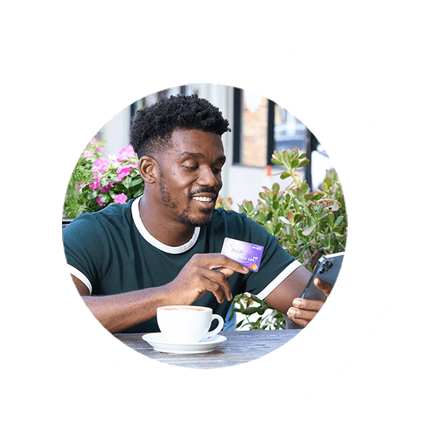 Donor drinking coffee, holding BioLife Debit card